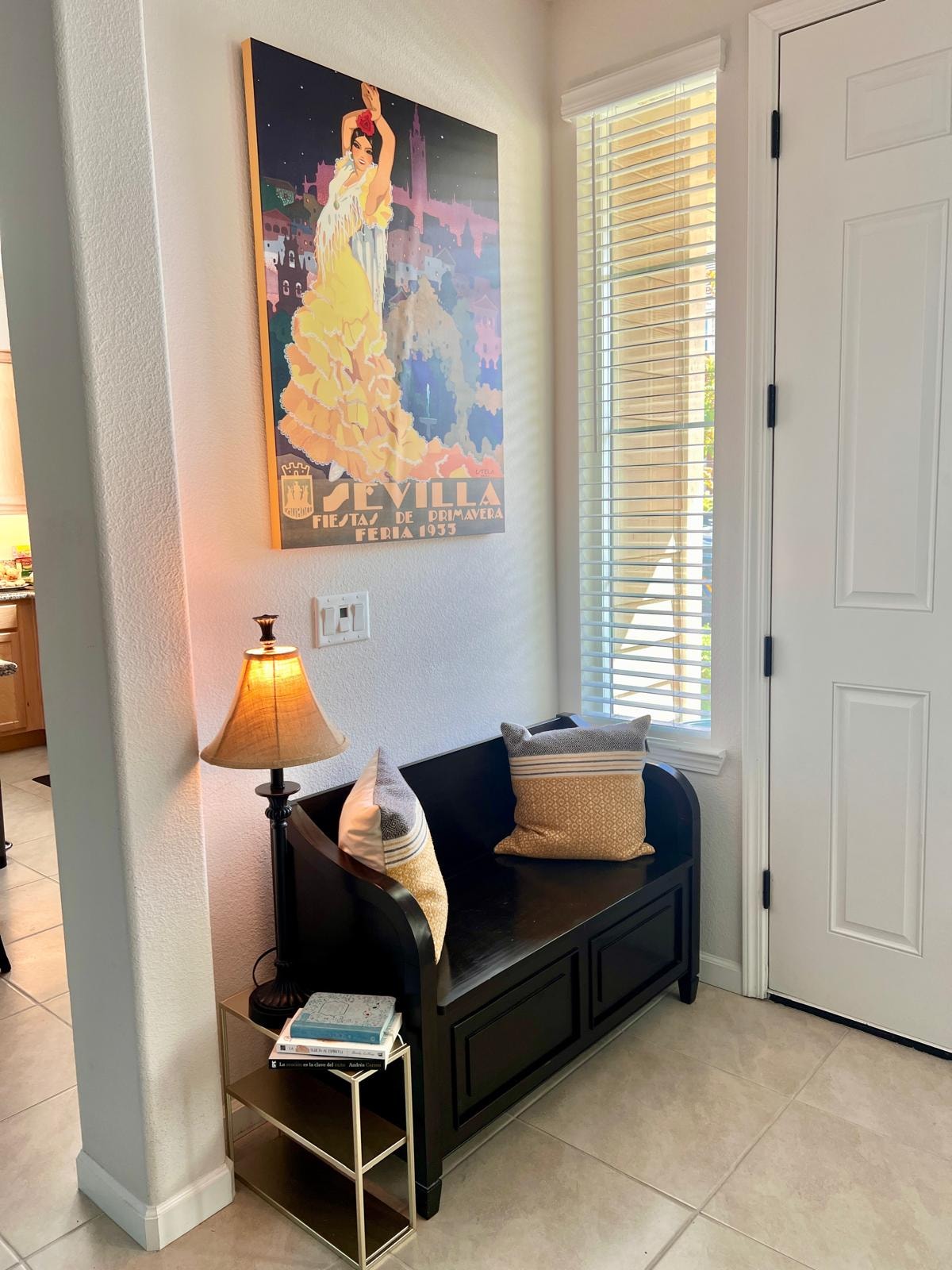Entryway nook with vintage poster and black bench