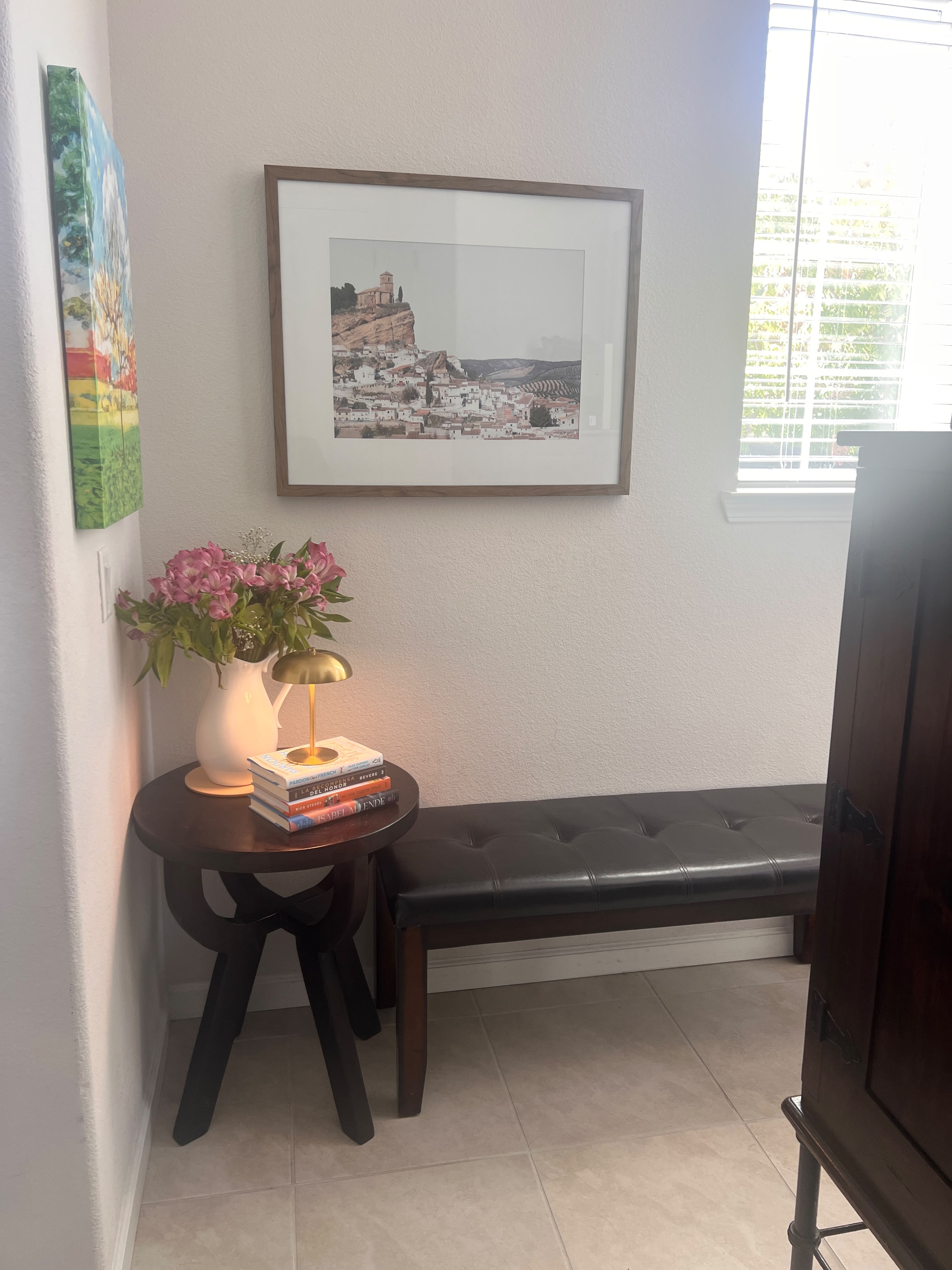 Modern entryway with framed landscape art and flowers